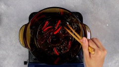 Cho 2 muỗng canh dầu ăn vào nồi, cho 3gr xuyên tiêu, 5gr ớt khô nguyên trái, 5gr ớt tươi vào đảo đều. Cho gà đã ướp vào xào săn khoảng 3 phút. Kế đến cho vào nồi 1,5 lít nước lọc, nấu chín gà 10 phút, hớt bọt cho nước lẩu được trong.