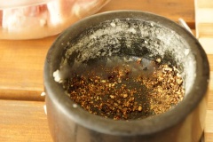 Hạt tiêu cho vào cối giã dập. Ớt trái cắt nhỏ.