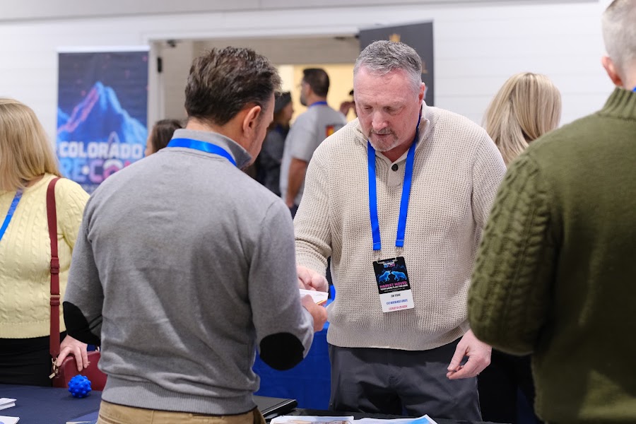 A handshake between attendees at Colorado RE•CON
