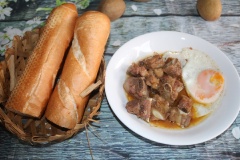 Cho Sườn kho ra đĩa sâu lòng, cho thêm một ít nước sốt vào để chấm bánh mì. Đặt trứng ốp la vào bên cạnh. Ăn cùng bánh mì giòn giòn, nóng nóng sẽ rất ngon nhé.