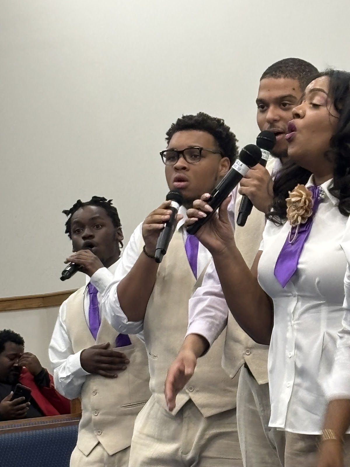Young singers group in white and beige outfits with purple ties at 16th Annual Homecoming Concert Revival