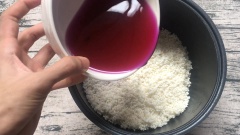 Cho nước lá cẩm vào, nếu như nước lá cẩm cho vào chưa sấp mặt nếp thì chúng ta có thể cho thêm nước vào.