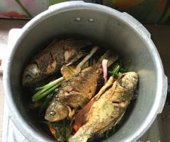 Xếp gừng, tỏi, hành xuống dưới nồi. Tiếp đó cho cá chép, xì dầu (nước tương), nước ấm vào nồi.