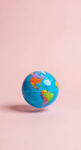 Bright Studio Shot of a Small Colorful World Globe on a Solid Pastel Pink Background