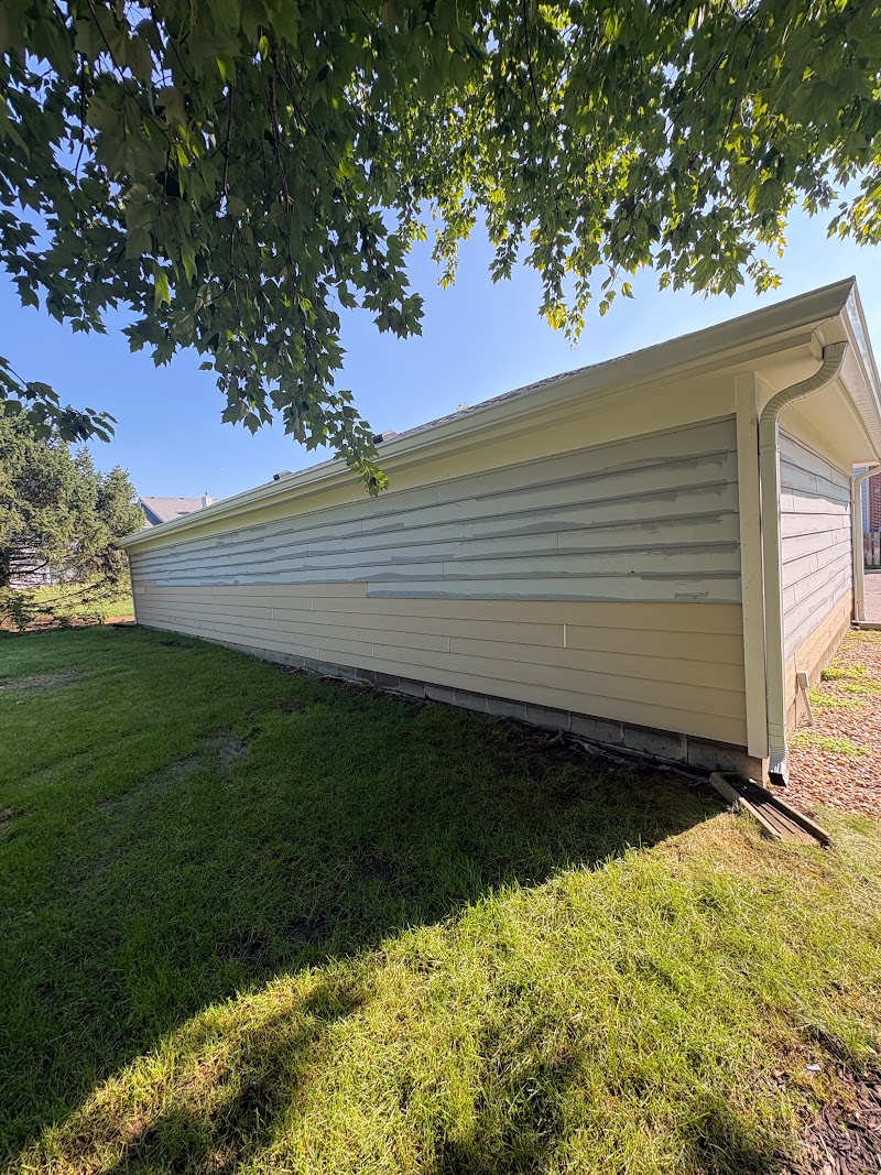 Detached garage wall at Hidden Creek Condominiums with new siding boards installed ahead of the repaint