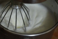 Chuyển sang phần lòng trắng. Cho nước cốt chanh và 1 muỗng cà phê muối vào. Đánh lòng trắng là công đoạn quan trọng nhất nên phải hết sức cẩn thận. Dùng máy đánh trứng ở tốc độ nhanh vừa, đánh bông cứng hỗn hợp lên như hình (theo dõi đánh không để lòng trắng mềm quá mà cũng ko để cứng quá. Khi hỗn hợp bông cứng thì đổ từ từ đường vào đánh cùng rồi đánh tiếp. Đánh thêm vài phút đến khi lòng trắng bông cứng, mịn, dẻo thì dừng lại.