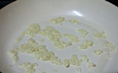 Tỏi bóc vỏ, băm nhỏ, cho vào chảo đã sử dụng ở trên, phi thơm. Tiếp theo, cho đùi ếch vào, xào thêm khoảng 5 phút.