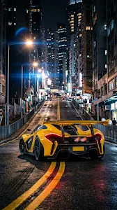 Rear View of a Yellow Supercar on a Steep City Street at Night