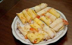 Xếp lên mỗi lát khoai tây một nửa con tôm và một ít phô mai mozzarella bào, cuốn chặt lại, cố định bằng tăm tre.