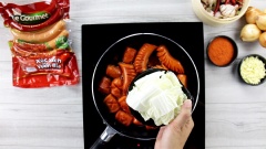 Tiếp theo bạn cho cải thảo đã cắt khúc vừa ăn vào, xào cho cải thảo chín. Sau đó thêm 3 miếng phô mai cheddar vào đảo cho phô mai tan chảy đều. Cuối cùng thêm hành boa rô vào.
