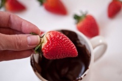 Sau khi được làm lạnh, lần lượt nhúng các trái dâu tây vào chocolate đen cho phủ đều thân trái dâu rồi để yên cho chocolate đông lại.