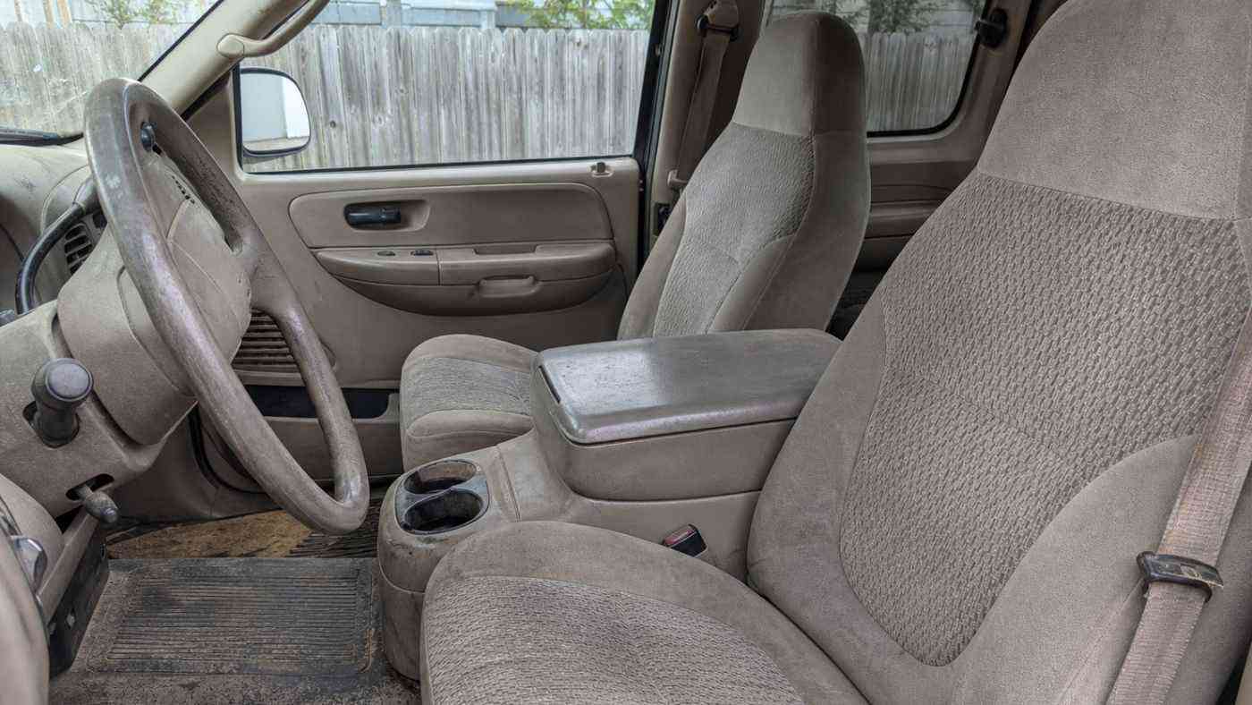 Worn gray Gen XII F-150 interior with cloth seats and dirty floor, showing why FX2 cab upgrades matter after years of use.