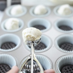 Kem phô mai đánh bông lên là được. Lót 12 chiếc bánh vào khuôn cupcake. Dùng muỗng múc kem múc từng viên kem phô mai lên trên bánh Oreo sao cho kem vượt mức khuôn một chút.
