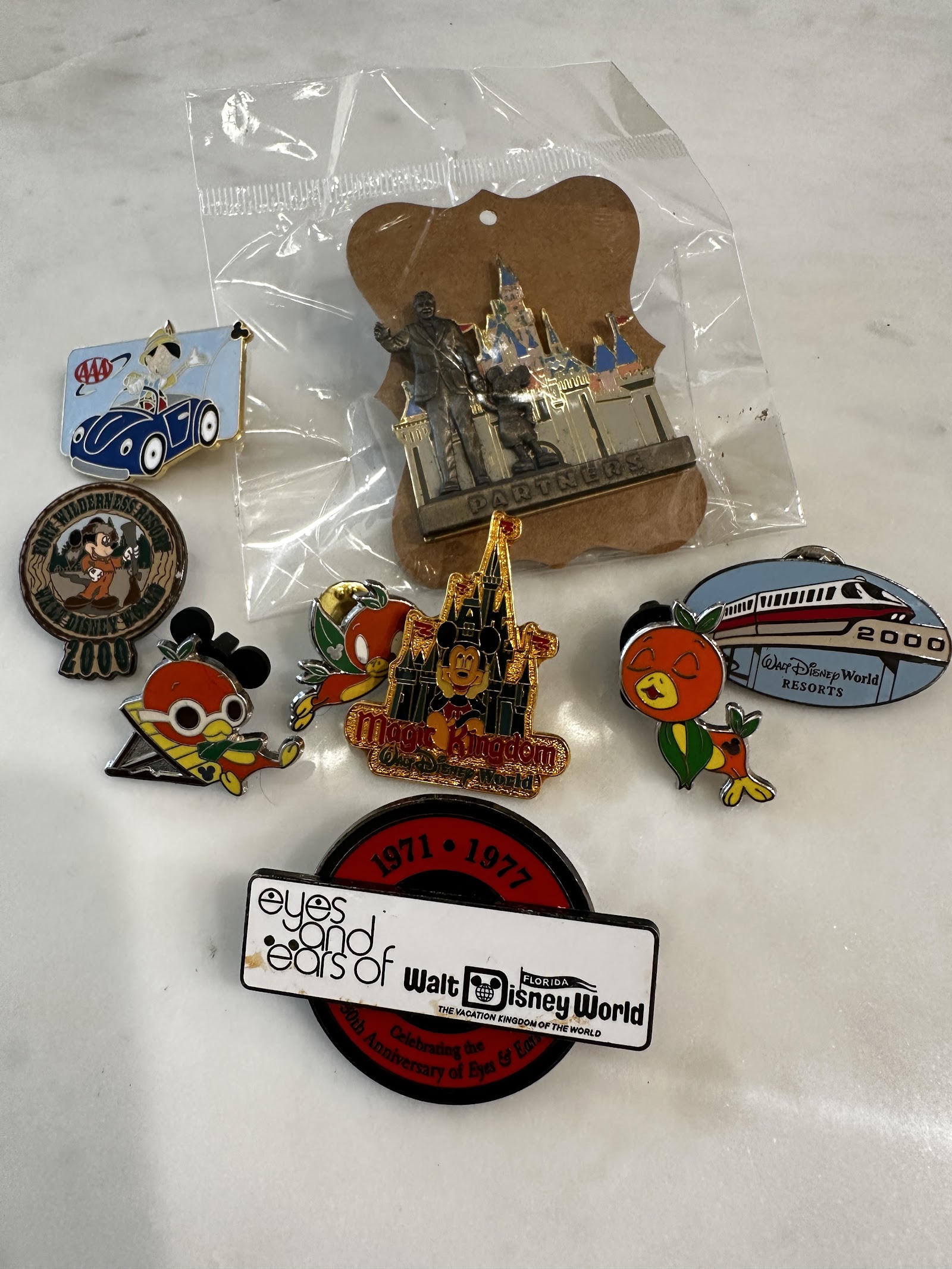 Collection of eight Disney Parks enamel trading pins including Monorail Red, Orange Bird, Partners Statue Walt and Mickey, Fort Wilderness Chip n Dale, and Eyes and Ears cast member anniversary pin