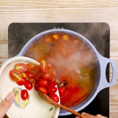 Cho tiếp cà chua cắt nhuyễn, cà chua bi vào và hầm 30 phút cho mềm. Sau đó, lược nước dùng cà chua qua rây.