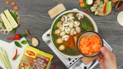 Cho hỗn hợp măng xào vào nồi, khuấy đều rồi nấu thêm 10 phút nữa. Sau đó cho thêm 100gr nấm mỡ, 100gr cà rốt tỉa hoa vào. Nêm nếm nước lẩu với 3 muỗng canh nước cốt me, 3 muỗng canh đường, 3 muỗng canh hạt nêm thịt thăn xương ống Maggi, 1/2 muỗng canh muối rồi khuấy lên cho gia vị hòa quyện là được.