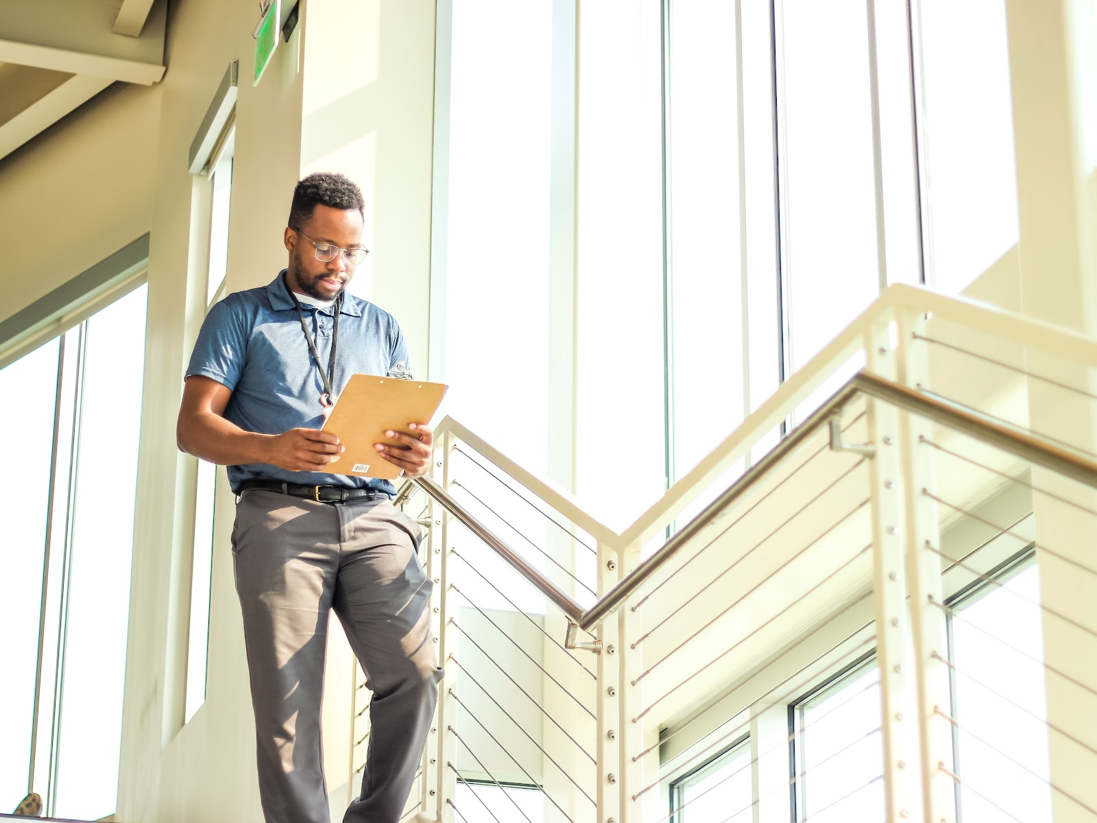 An intern walks down the stairs holding a clipboard 