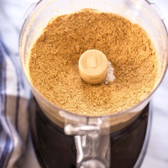 Bánh quy bạn cho vào máy xay thực phẩm và xay cho nhuyễn mịn. Cho bơ đã được làm tay chảy, tinh chất vani, đường bột, muối, bơ đậu phộng trộn đều với nhau rồi trộn tiếp tục với bánh quy vụn.