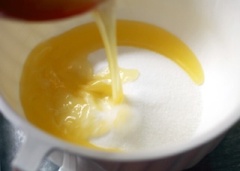 Tiếp theo, đổ bơ lạt đã tan chảy vào chén đường, khuấy đều để đường tan hết.