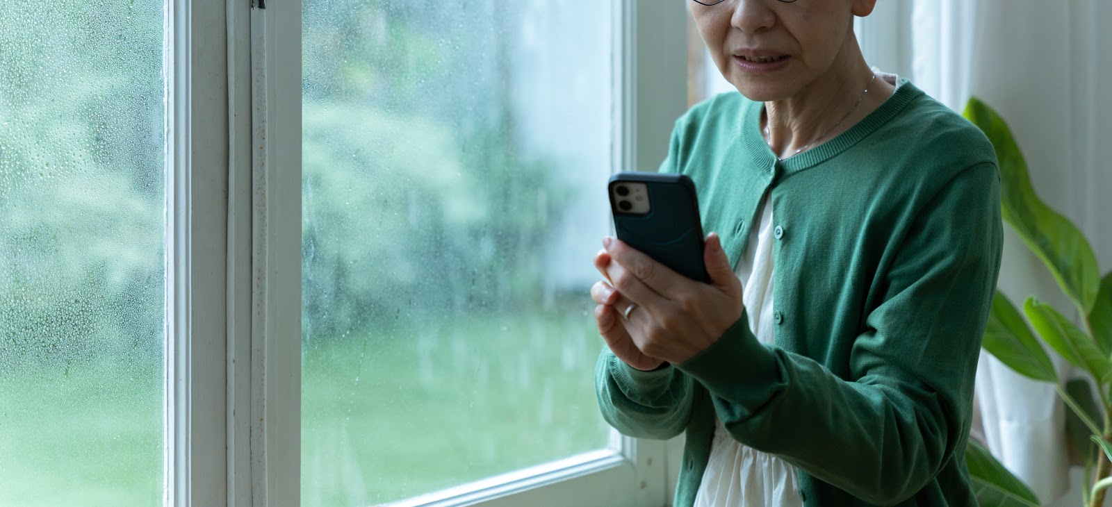 雨の日にスマホで気象情報を確認する様子