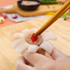 Quết cá thác lác với 1 muỗng canh đầu hành lá băm, 1 muỗng canh tiêu xanh đập dập. Tẩm một ít bột năng vào bên trong hoa mực để tạo độ kết dính cho mực và nhân, nhồi cá thác lác đã quết vào bên trong mực cho đầy, ấn ớt sừng lên mặt.