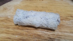 Trải lá bánh rế ra thớt, thấm nước nhẹ nhàng rồi cho nhân lên trên, cuộn lại thành cuốn chả giò.