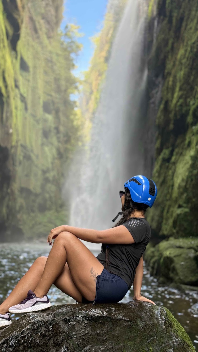 Turista equipada com capacete de segurança contempla a queda da Cachoeira do Véu da Noiva, localizada no Cânion do Ribeirão Lajeado Grande em Jaguariaíva, Paraná, durante atividade de ecoturismo.