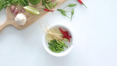 Tỏi bóc vỏ cho vào cối, thêm vào 13 trái ớt xanh, 4 trái ớt đỏ và 2 gốc ngò rí, dùng chài giã cho các nguyên liệu nát và nhuyễn nhé! Sau đó thêm vào 40g đường và 1/2 muỗng cà phê bột ngọt, giã tiếp cho hỗn hợp quyện đều vào nhau.