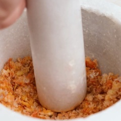 Vớt tôm khô ra để ráo nước. Rồi chia tôm thành từng phần cho vào cối giã gần nát.