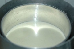 Đặt nồi hấp lên bếp, đổ 1 lớp bột đậu xanh chừng 2 cm vào khuôn, đậy vung, hấp trong khoảng 5-7 phút.