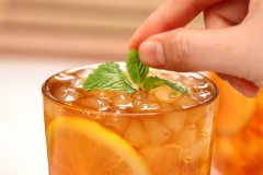 Cho đá vào ly, đổ trà đã shake vào, thêm 2 vá trân châu trắng lên trên, trang trí lát chanh vàng và húng lũi để ly trà được đẹp mắt hơn.