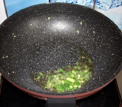 Hành lá thái nhỏ. Sau đó xào thơm hành lá với 1 muỗng canh dầu mè, cho vào 5 muỗng canh sốt ớt đậu xay, khuấy đều.
