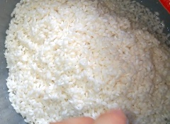 Cho gạo nếp đã ngâm vào nồi cơm điện, cho phần đậu đã luộc lên và trộn đều. Nấu một nồi nước sôi và đổ nước sôi vào phần gạo nếp đã trộn cùng đậu. Cho nước xâm xấp mặt nếp (0.3 - 0.5 cm). Bật nút nấu chín như nấu cơm.