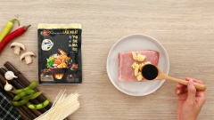 Cho 100gr thịt heo vào tô ướp cùng 10gr tỏi bóc vỏ, 2 muỗng canh nước tương, 1 muỗng canh dầu mè, rồi dùng bao tay bóp đều và ướp khoảng 10 phút để thấm đều gia vị.
