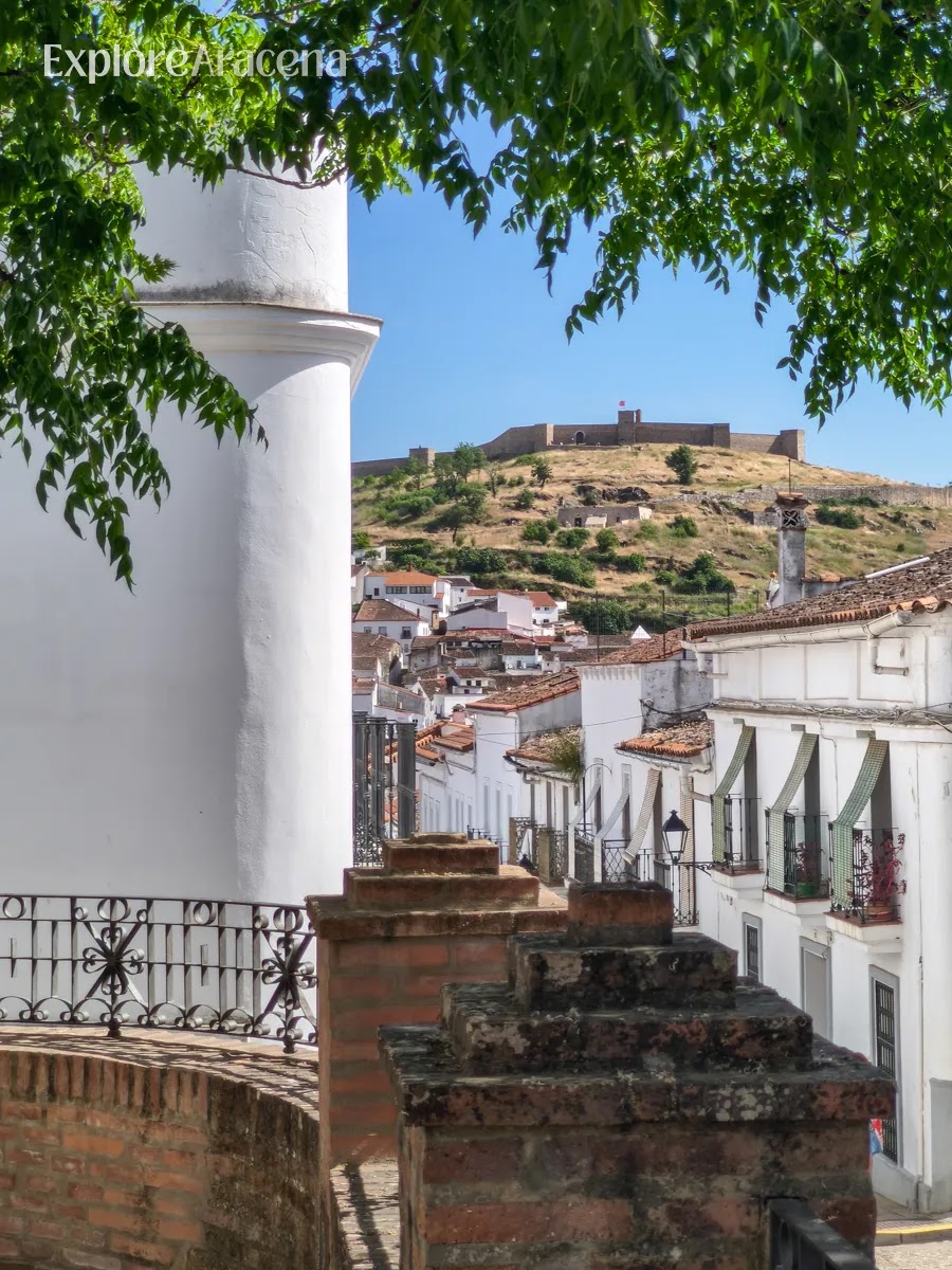 Whitewashed streets of Aracena with the Castillo de Aracena visible in the background.