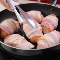 Cuộn ức gà đã ướp với ba rọi xông khói Le Gourmet, cuộn chặt tay để thịt không bị bung ra. Cho cuộn thịt vào áp chảo với lửa vừa đến khi vàng đều các mặt thì lấy ra.