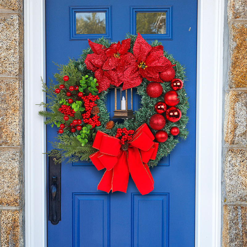 Christmas wreath with decorative lantern and red flowers