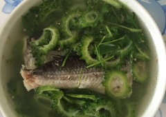 Đun nóng 2 muỗng canh dầu ăn, cho cá đã ướp vào chiên sơ qua rồi cho 1 lít nước vào, thêm khổ qua, đun sôi khoảng 15 phút. Sau đó nêm ngò rí, 2 muỗng cà phê hạt nêm, 1 muỗng canh nước mắm, 1/2 muỗng cà phê bột ngọt, khuấy đều cho tan gia vị rồi tắt bếp.