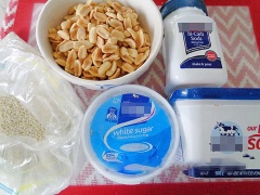 Cho 1/2 chỗ mè rang lên khay có lót giấy chống dính (giấy dầu). Trong nồi nhỏ, cho vào 230g đường, 60ml nước, 1 muỗng canh nước cốt chanh và 1/8 muỗng cà phê muối cho vào nồi hòa tan. Bắc lên bếp nấu lửa vừa trong 5 phút. Tiếp đến, hạ thấp lửa nấu cho đến khi nước đường ngả màu vàng (đừng để quá vàng) thì cho 20g bơ và 1/3 muỗng cà phê baking soda vào khuấy đều 20 giây.