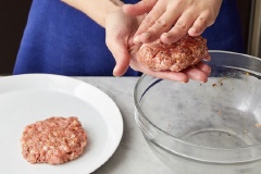 Cách làm nhân bánh hamburger: Trong một chiếc bát, cho thịt heo xay, gừng thái nhỏ, phần nước sốt tương đen còn lại, thêm 1/2 muỗng cà phê muối và hạt tiêu vào trộn đều. Chia hỗn hợp thịt thành 2 phần bằng nhau có độ dày khoảng 1,25cm. Để riêng ra đĩa. Đun nóng chảo cùng chút dầu olive, cho thịt heo đã viên vào chiên mỗi mặt khoảng 3 - 5 phút hoặc cho đến khi thịt chín, sém cạnh. Gắp ra đĩa, dùng giấy bạc bọc lại để thịt nóng.
