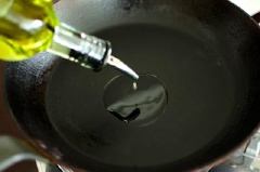 Làm nóng dầu ăn trong chảo, dùng môi múc hỗn hợp bí đỏ, bột mì vào, dàn đều ra.