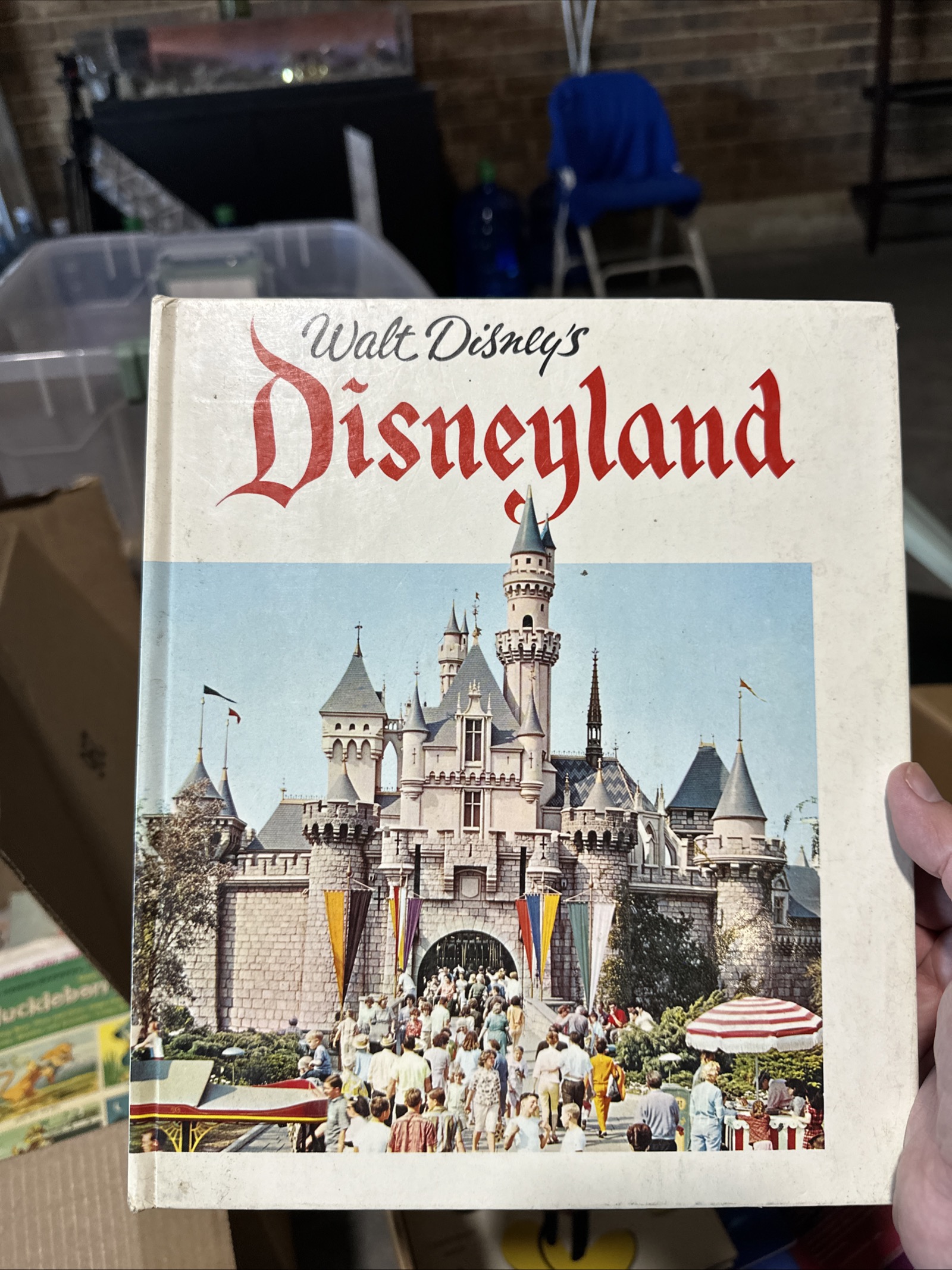 Vintage 1960s Walt Disney's Disneyland hardcover souvenir guidebook with Sleeping Beauty Castle on a light blue sky cover and red stylized Disneyland lettering