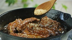Rim lửa liu riu cho nước sốt keo lại. Dùng muỗng rưới sốt lên cây sườn để sườn thấm đều gia vị hơn. Đến khi nước sốt keo lại còn 1/3 thì tắt bếp, rắc lên sườn 1 muỗng canh mè trắng rồi trộn đều.