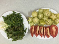 Khế cắt rìa, rửa sạch, cà chua bổ múi cau, hành lá, ớt và rau răm cắt nhỏ.