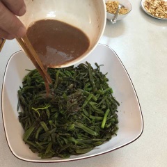 Vớt rau muống ra, cho hỗn hợp mắm tôm vào, trộn đều.
