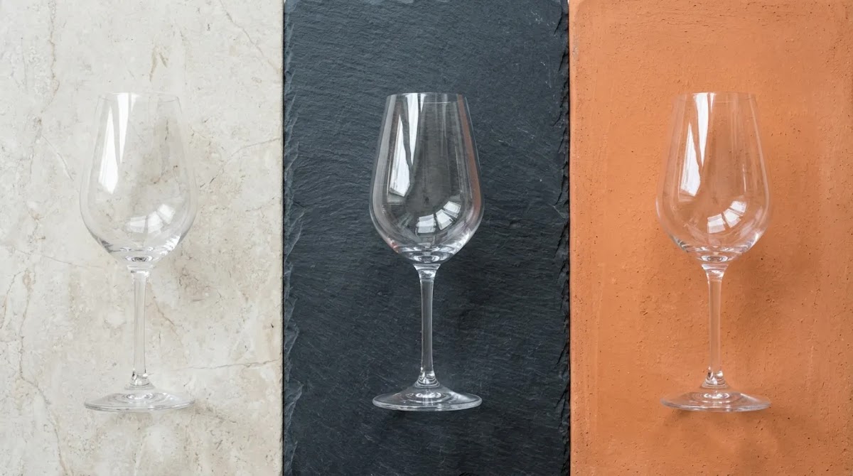 Editorial tasting-glass scene representing Lambrusco characteristics from pale to dark Italian sparkling red styles