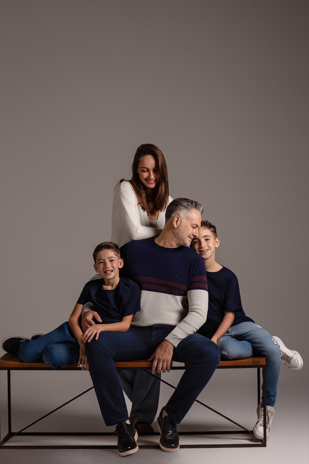 Retrato de fam�lia sentado em banco com fundo neutro para campanha da JCanedo.