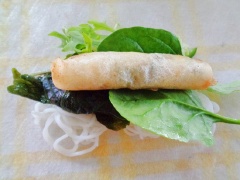 Bánh tráng mỏng thoa nước. Sau đó cho bún, xà lách, rau thơm các loại cùng cuốn nem, gấp hai bên, nhẹ nhàng cuộn lại.