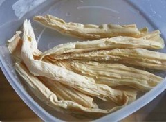 Ngâm mềm tàu hũ ky trong nước ấm. Sơ chế các loại rau củ và cắt khúc dài bằng nhau.