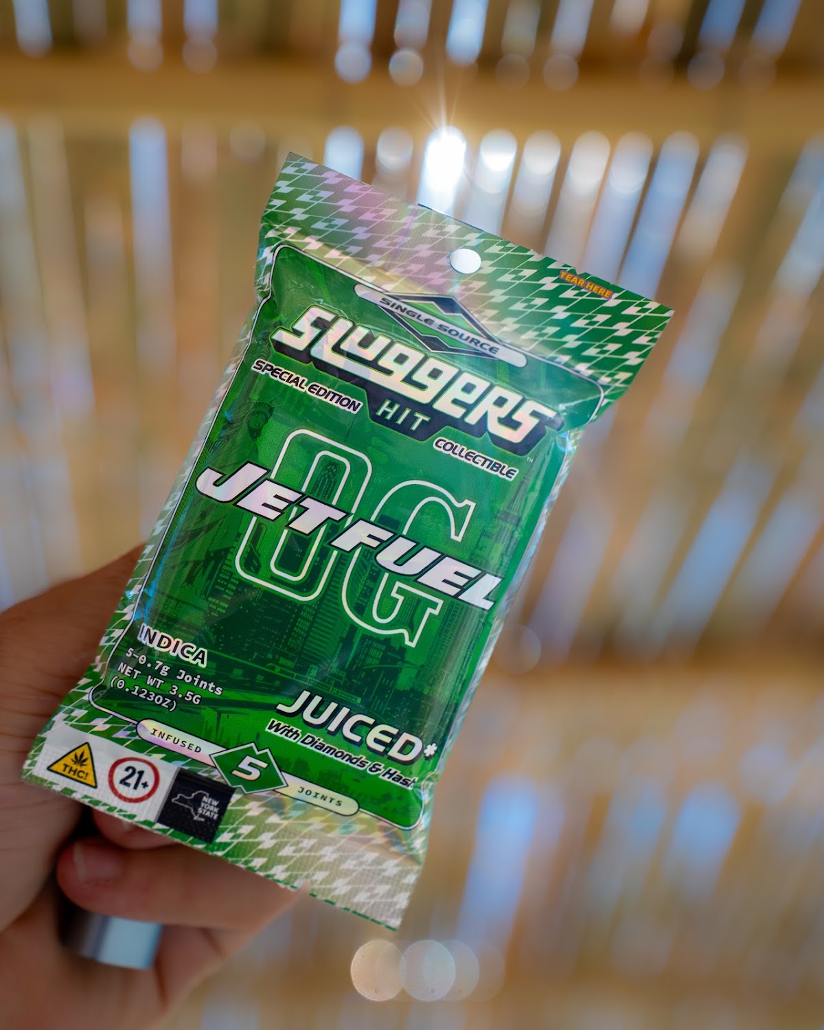 Holographic cannabis pre-roll pack held up — cannabis product photography